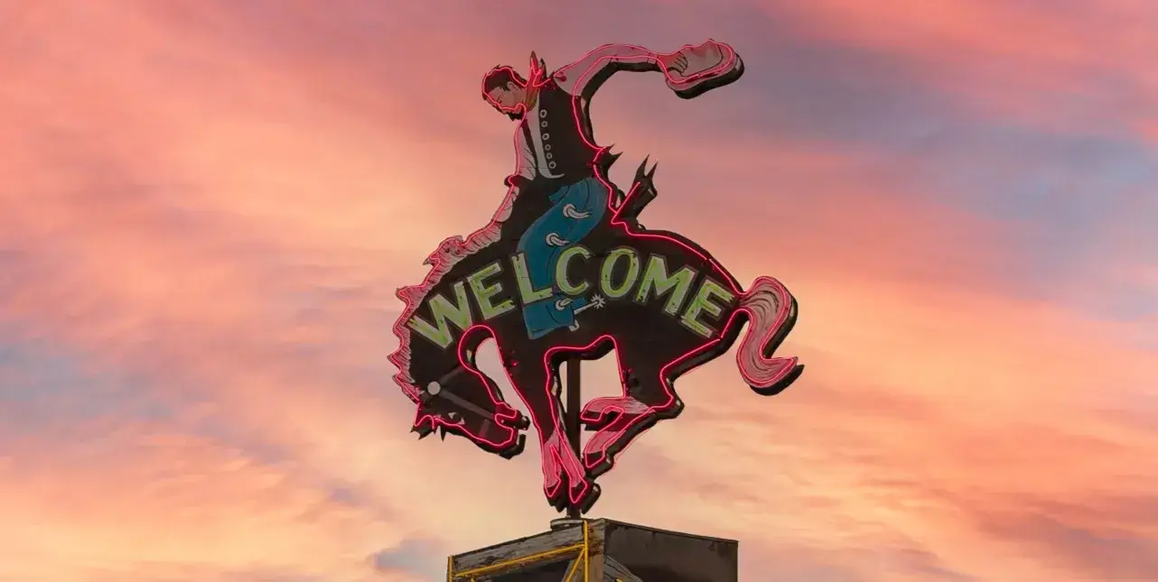 cowboy riding bull welcome sign in Wyoming